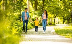 família em passeio no parque com filho e cachorro