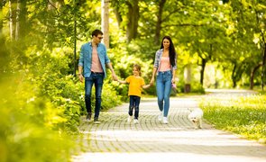 família em passeio no parque com filho e cachorro