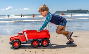 menino empurrando caminhão de brinquedo