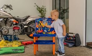 criança organizando ferramentas para brincar em casa