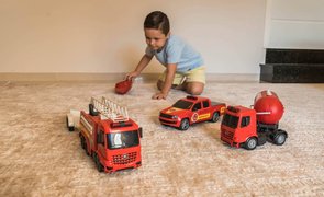 crianca brincando de carrinho na sala de casa