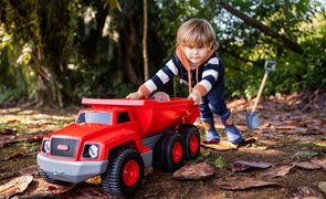 criança brincando com caminhão caçamba