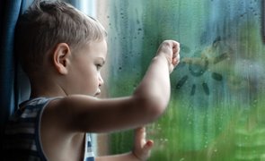 criança dentro de casa em dia de chuva