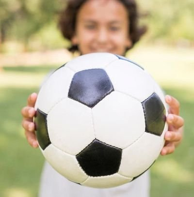 menino segurando bola de futebol