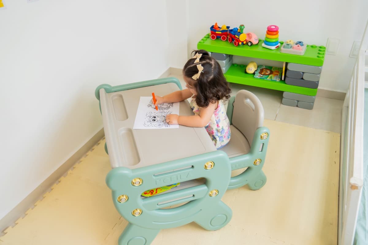crianca fazendo desenhos em folha de papel