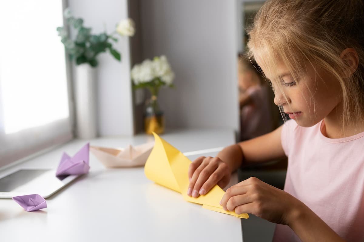 menina fazendo dobraduras em papel