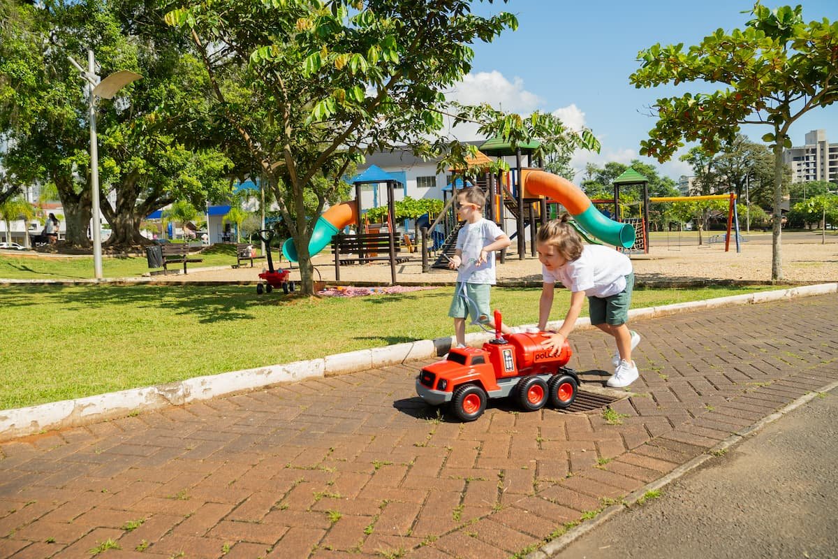 crianças brincando com caminhão de brinquedo em parque
